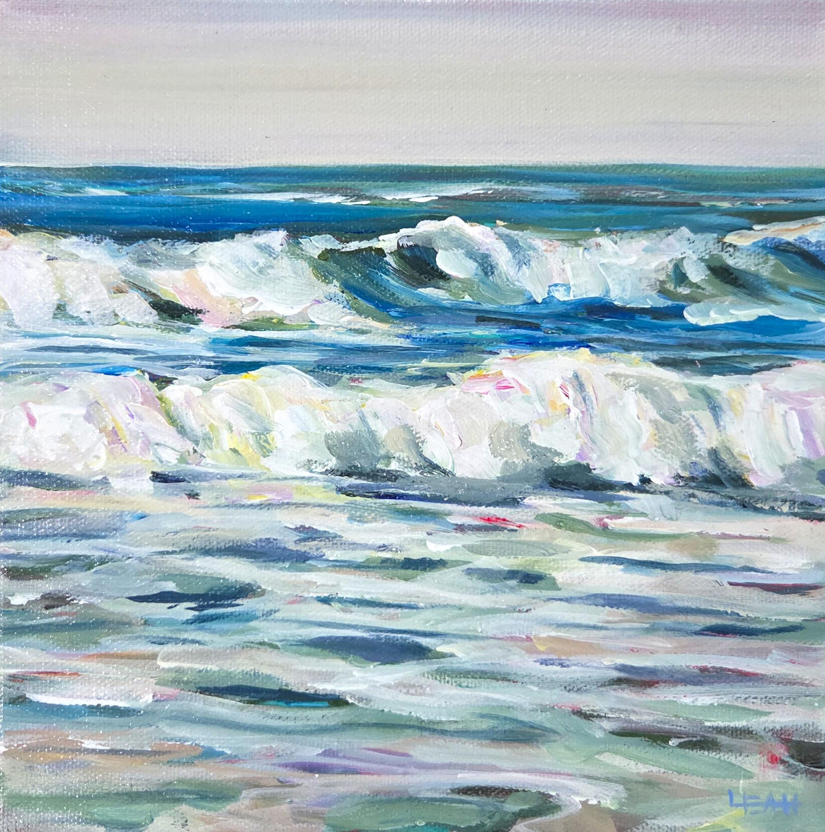 A square canvas painting of ocean waves, displayed on a light-colored wooden background. The painting features textured brushstrokes in shades of blue, white, and green, with a soft lavender-gray sky at the top.