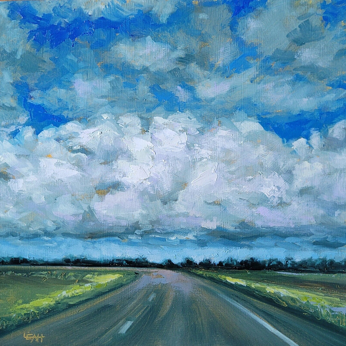 A square canvas painting of a rural road stretching through green fields under a dramatic blue and white cloudy sky, displayed on a wooden surface.